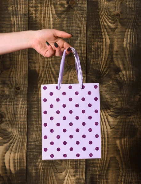 Sac à provisions blanc tacheté à la main féminine sur fond en bois — Photo