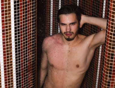 Yakışıklı kaslı seksi adam duşta yıkanıyor.