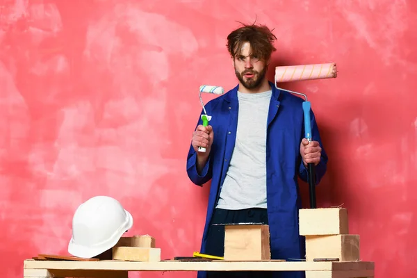 Constructor hombre sosteniendo rodillos de pintura — Foto de Stock
