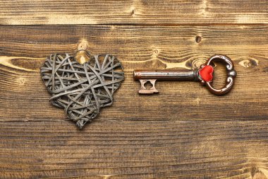 Gümüş kalp ve Sevgililer dekorasyon olarak ahşap üzerine metalik anahtar