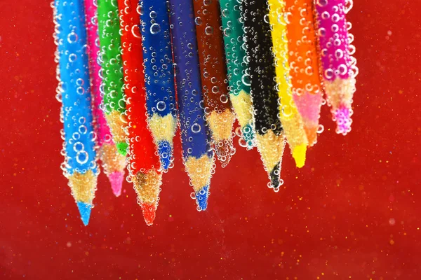 Kleurpotloden in bruisend water — Stockfoto
