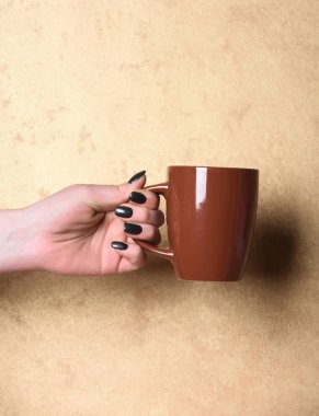 kahverengi çay veya kahve Kupası el üzerinde dokulu arka plan