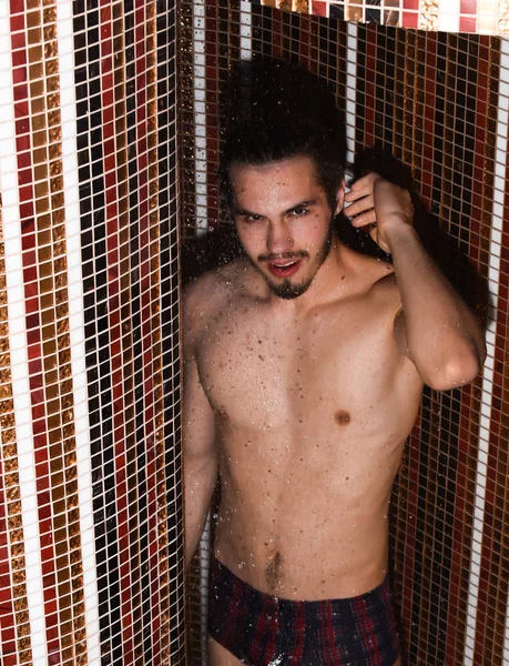 Handsome man washes in shower