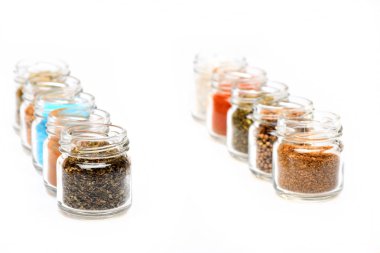 beyaz zemin üzerine kavanoz içinde çeşitli baharatlar