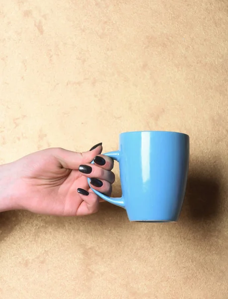 Chá azul ou xícara de café na mão sobre fundo texturizado — Fotografia de Stock
