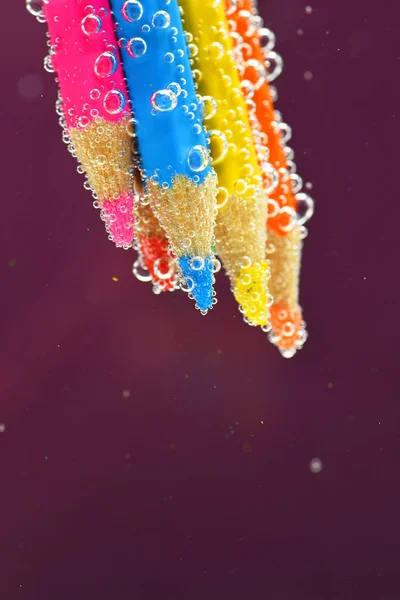 Colored pencils in sparkling water — Stock Photo, Image