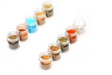 beyaz zemin üzerine kavanoz içinde çeşitli baharatlar