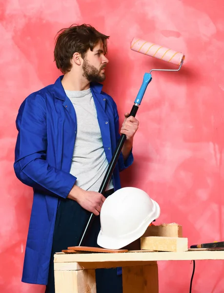 Constructor hombre sosteniendo rodillo de pintura — Foto de Stock