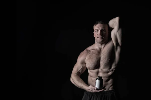 Bel homme d'athlète sexy avec le corps musculaire détient pot ou récipient en plastique — Photo