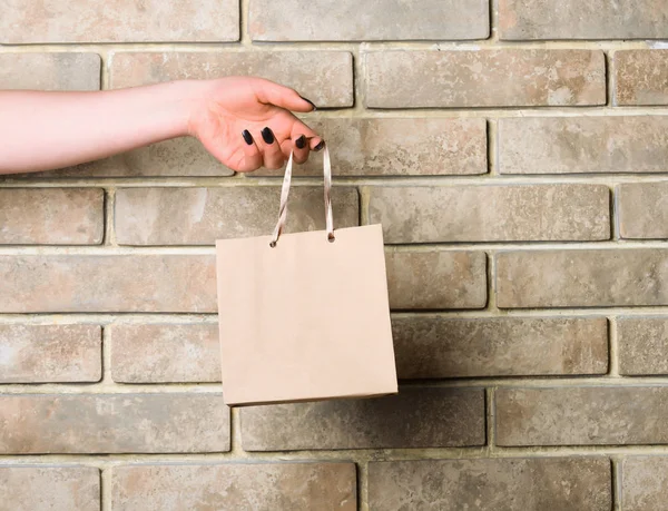 Bolso Cabás blanco en mano femenina sobre pared de ladrillo — Foto de Stock