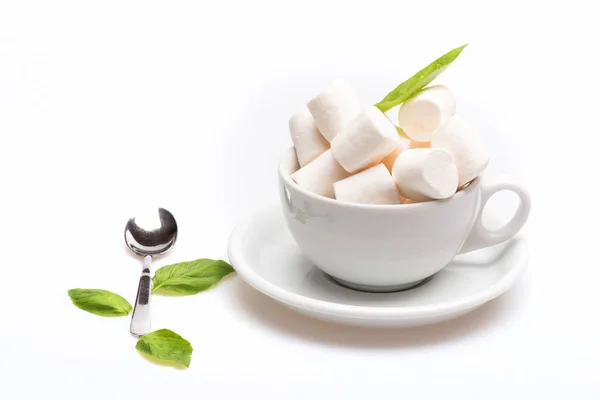 Kopp med marshmallow på tallrik med sked och basilika — Stockfoto