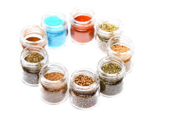 beyaz zemin üzerine kavanoz içinde çeşitli baharatlar