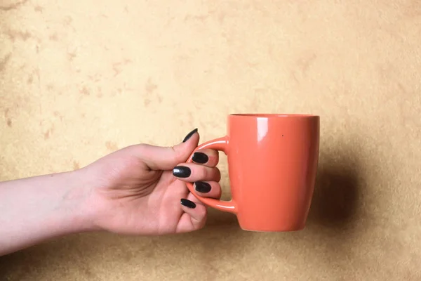 Chá vermelho ou xícara de café na mão sobre fundo texturizado — Fotografia de Stock