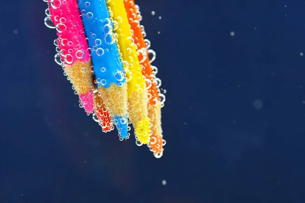 Lápices de colores en agua con gas — Foto de Stock