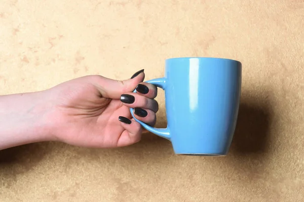 Chá azul ou xícara de café na mão sobre fundo texturizado — Fotografia de Stock