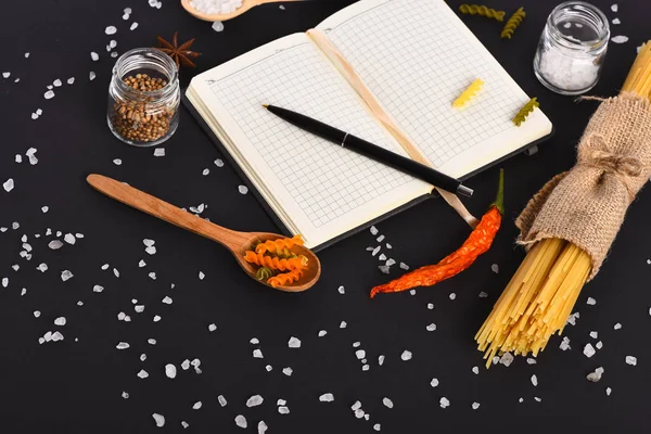 Caderno aberto com caneta e macarrão italiano colorido — Fotografia de Stock
