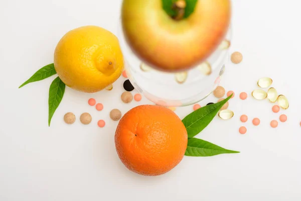 Olika frukter: citron, apelsin, äpple med vinglas, piller, kapsel — Stockfoto
