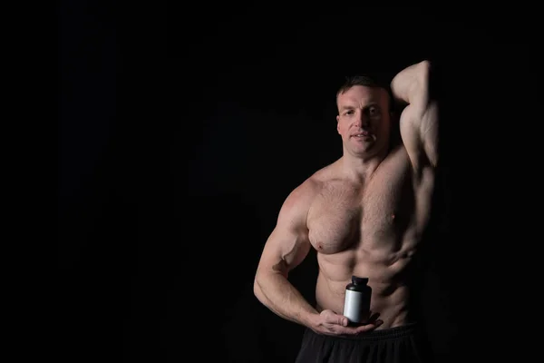 Bello uomo atleta sexy con il corpo muscolare tiene vaso di plastica o contenitore — Foto Stock