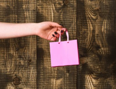 ahşap arka plan üzerinde kadın elinde pembe alışveriş çantası