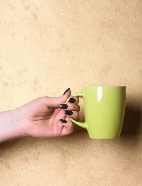 Chá verde ou xícara de café na mão sobre fundo texturizado — Fotografia de Stock