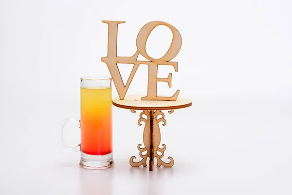 Alcohol cocktail in glas op kleine decoratieve tafel, liefde inscriptie — Stockfoto