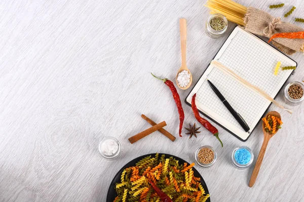 Kleurrijke Italiaanse pasta en open notebook met pen — Stockfoto