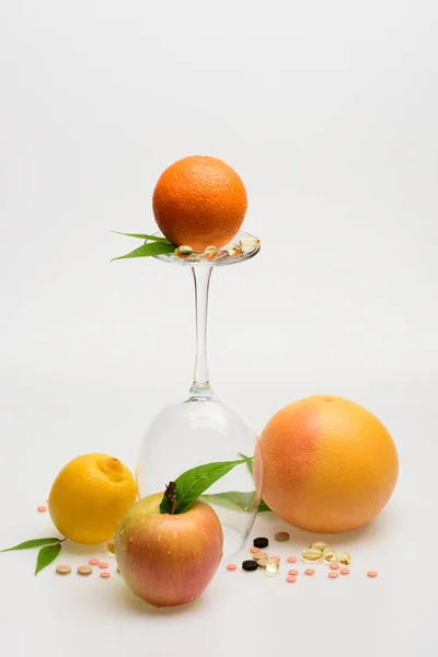 Apelsin, grapefrukt, äpple och citron, vinglas med piller och kapsel — Stockfoto