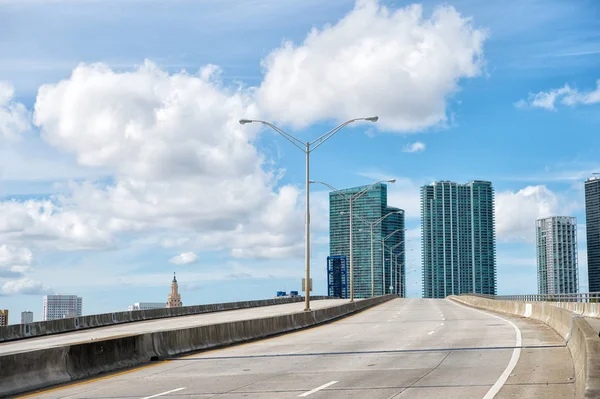 Autostrada z wieżowców na zachmurzone niebo niebieski — Zdjęcie stockowe