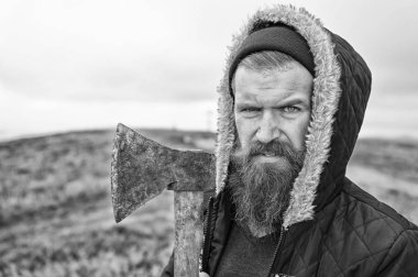 Sakallı yakışıklı ciddi adam dağ üstüne paslı balta ile