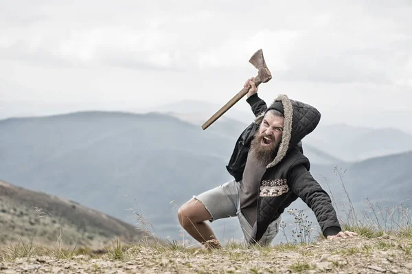 Hombre barbudo, brutal hipster con bigote sostiene hacha en la montaña — Foto de Stock