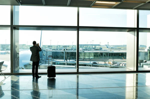 Man with luggage waiting hall of airport at window glass — Stock Photo, Image