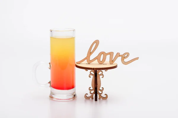 Coquetel de álcool em vidro na pequena mesa decorativa, inscrição de amor — Fotografia de Stock