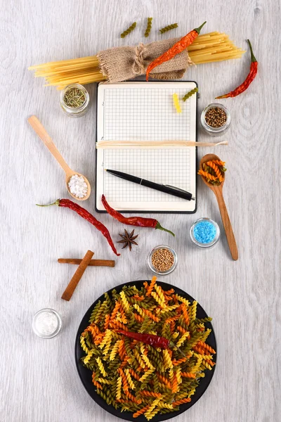 Kleurrijke Italiaanse pasta en open notebook met pen — Stockfoto