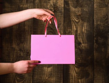 ahşap arka plan üzerinde kadın elinde pembe alışveriş çantası