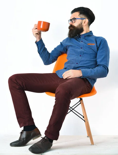 Szakállas férfi, brutális fehér hipszter, bajusszal a kezében narancssárga bögre — Stock Fotó