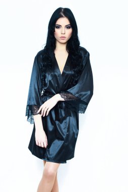 Siyah ipek bornozla poz veren seksi kız, beyaz tenli.