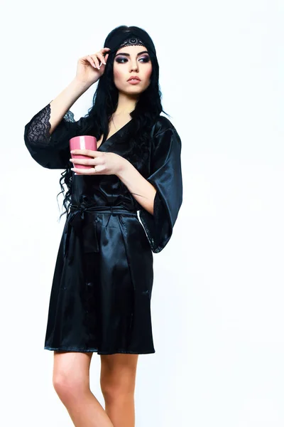 Fille sexy posant en robe de soie noire avec tasse — Photo