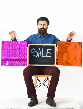 Sakallı adam, bıyıklı vahşi beyaz hippi alışveriş paketlerini tutuyor.