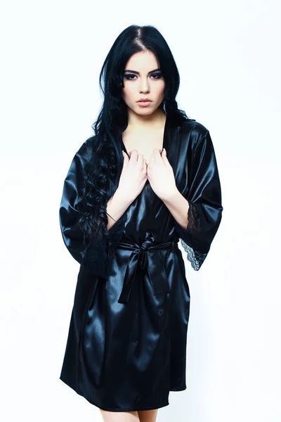Сексуальная девушка, позирующая в черном шелковом халате изолированная на белом — стоковое фото