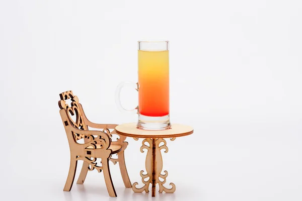 Cóctel de alcohol en vidrio sobre una pequeña mesa decorativa con silla — Foto de Stock