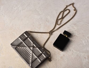 Metalik zinciri parfüm yakınındaki küçük kadının metalize gümüş çanta