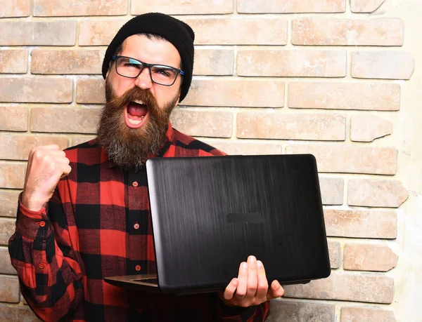 Бородатий жорстокий білий хіпстер тримає ноутбук — стокове фото