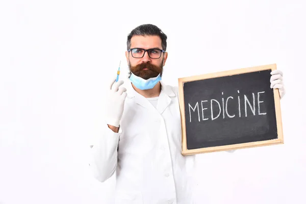 注射器と医学の碑文とボードを保持しているひげそりの白人医師 — ストック写真