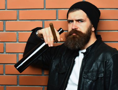 Sakallı, Kafkas hippisi elinde şişe, puro içiyor.