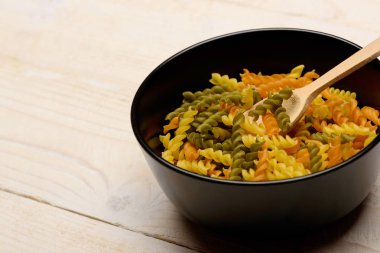 Ahşap arka plan üzerinde renkli düdük makarna