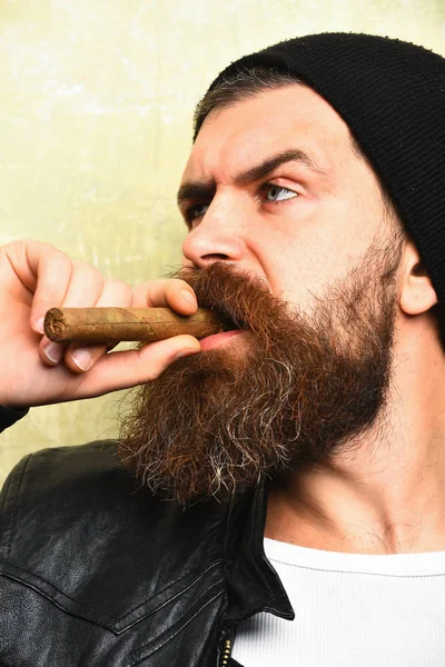 Bearded brutal caucasian hipster smoking cigar