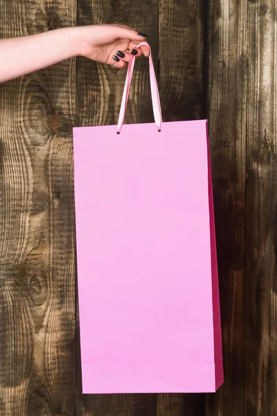 Bolso Cabás rosa en mano femenina sobre fondo de madera — Foto de Stock