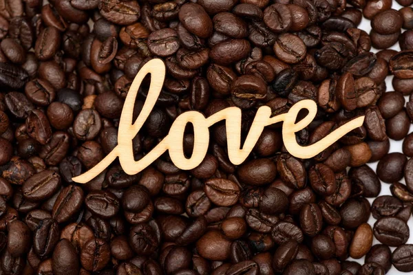 Ziarna kawy i drewniane iscription słowo miłości — Zdjęcie stockowe
