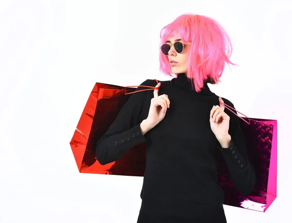 Menina sexy na moda em rosa peruca segurando pacote ou sacos — Fotografia de Stock
