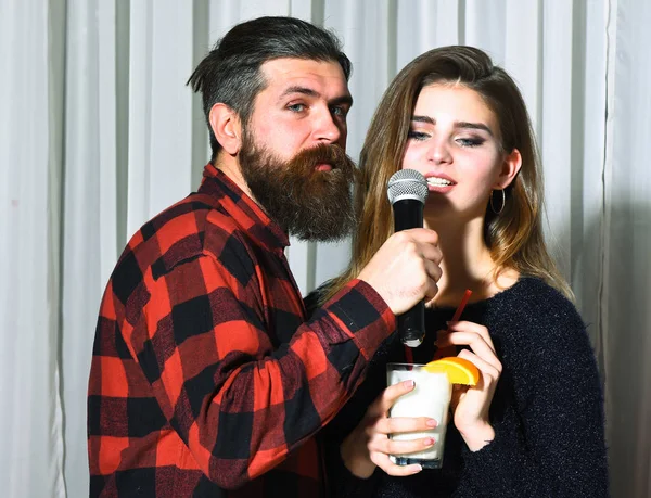 Mooi meisje en bebaarde man met baard in karaoke bar — Stockfoto